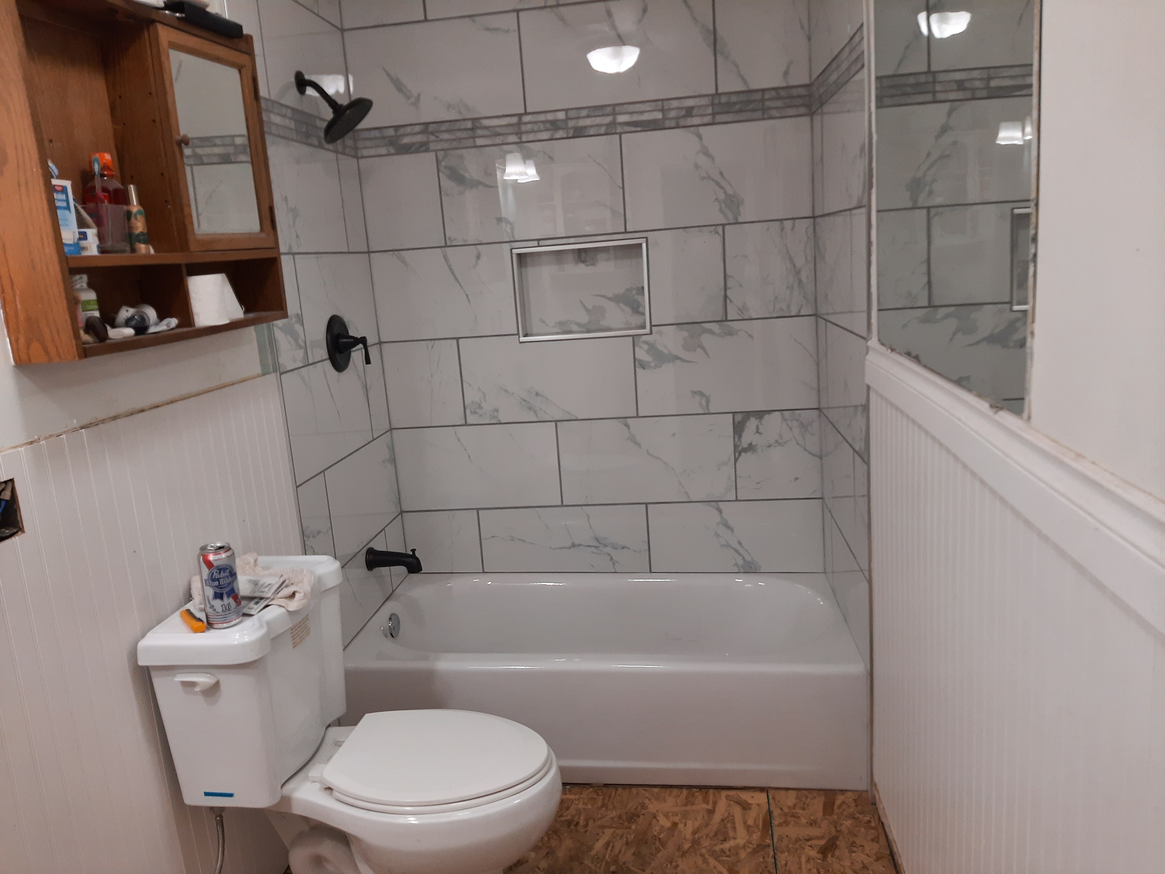 Marble-look tub surround with beadboard wainscoting and cork floor