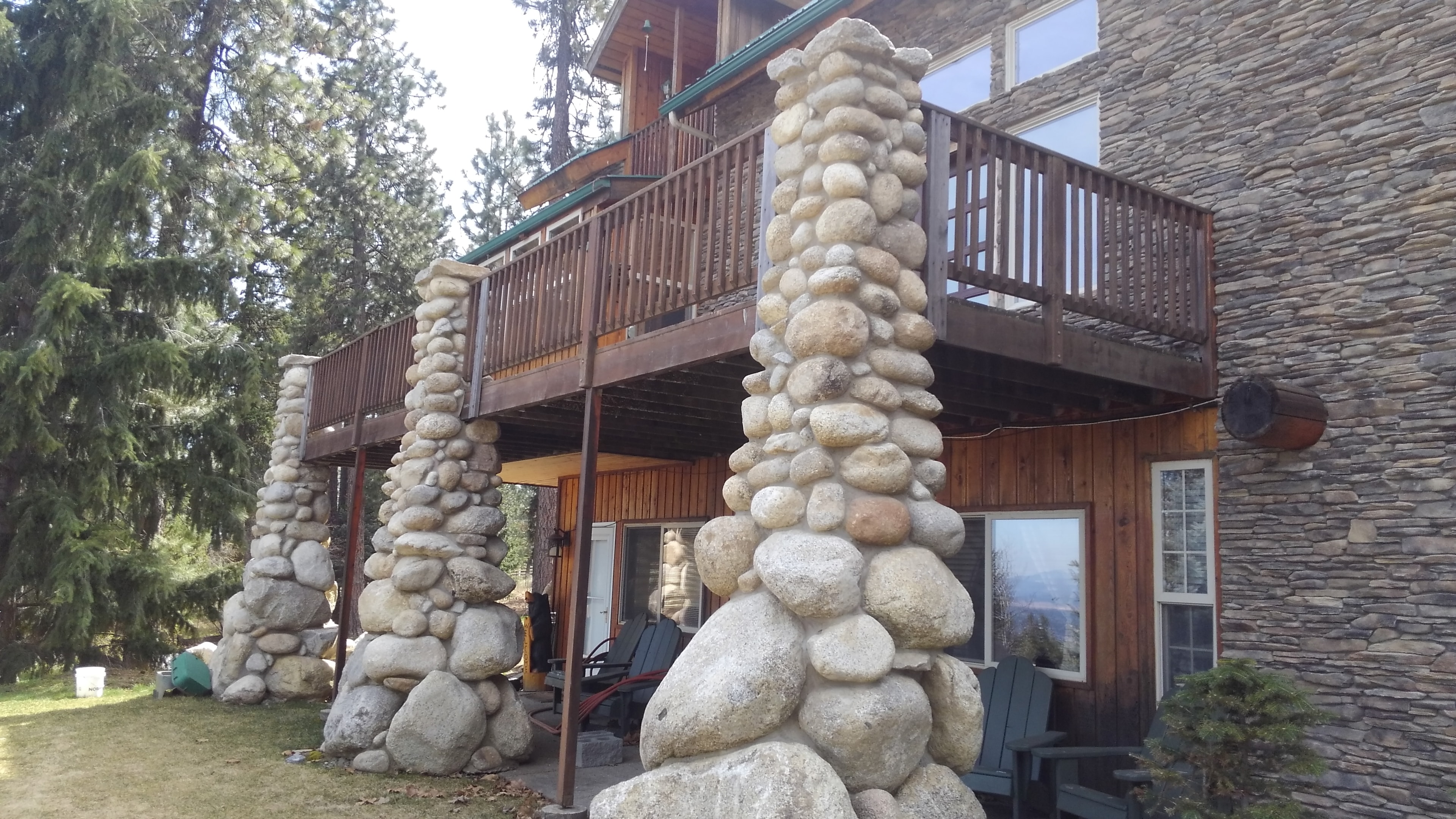 Mountain lodge with river rock columns and upper deck