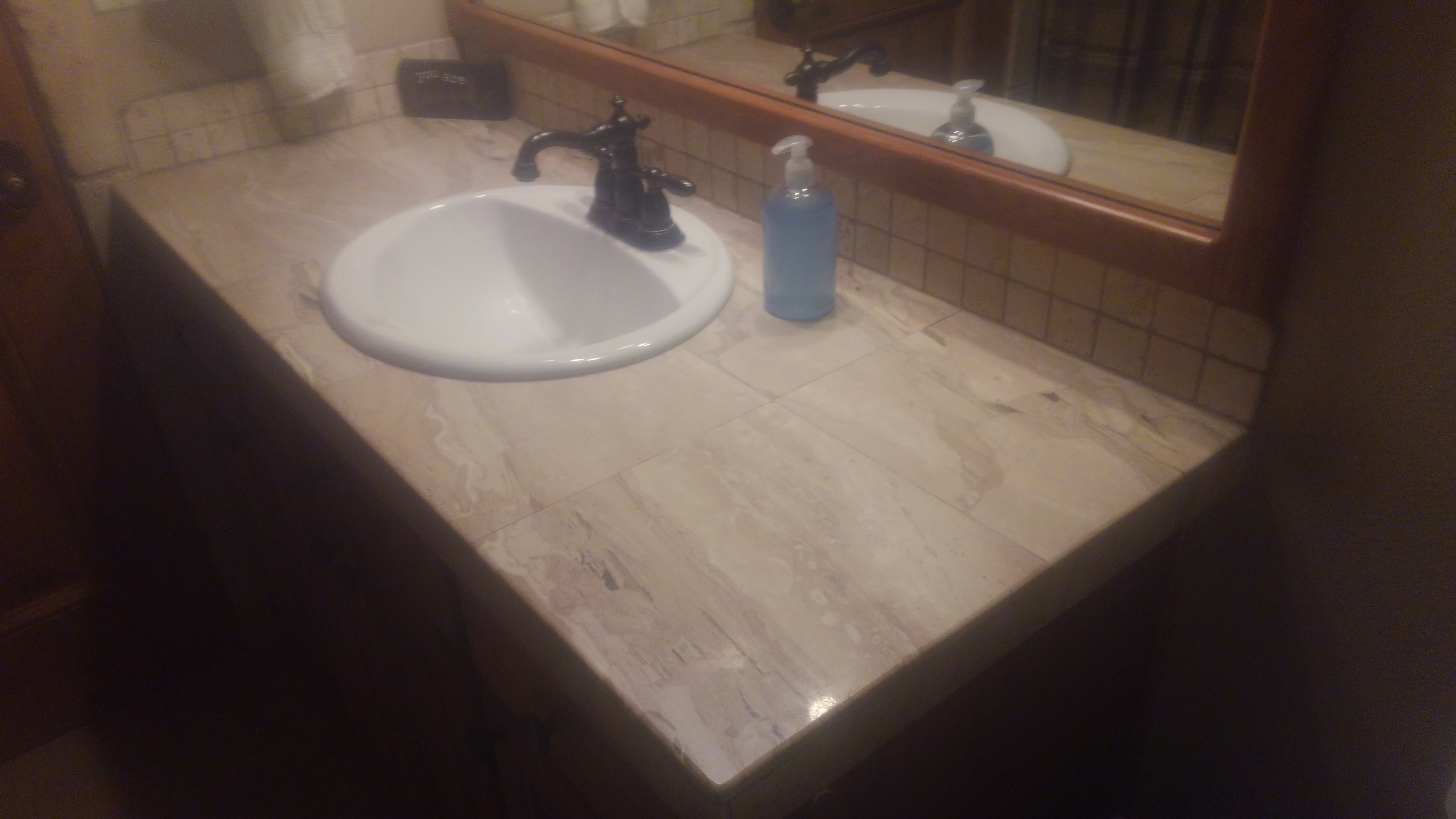 Travertine shower wall with diamond tile border detail